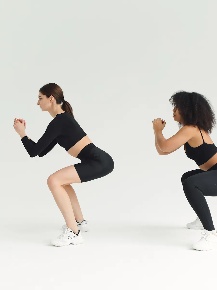 Two students mid-squat in a FIT HIIT class
